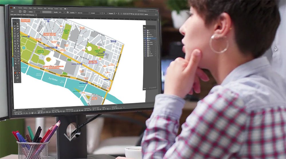 Géomaticienne devant son écran et dessinant une mappemonde